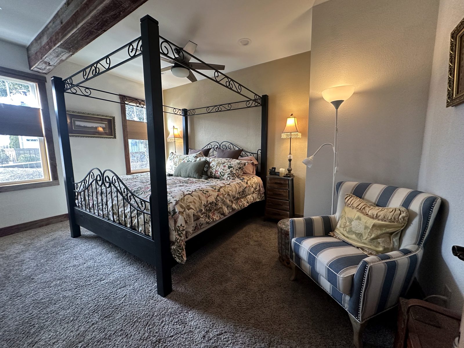 King wrought-iron canopy bed beside the bedroom windows