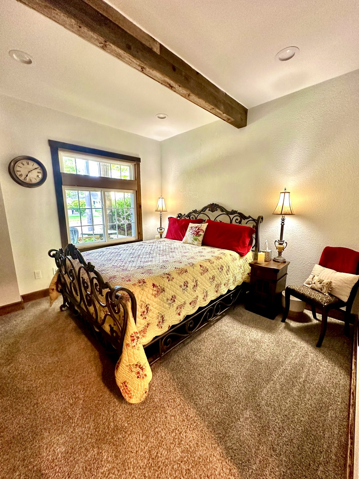 Queen bedroom with wrought-iron bed and original wood beam