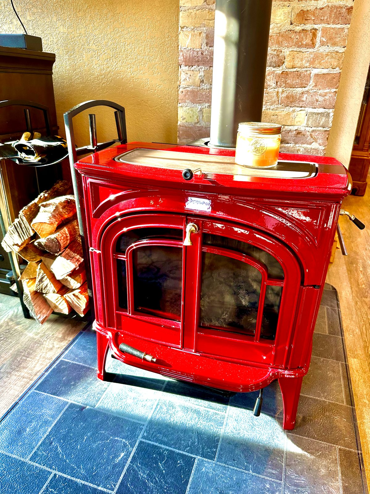 Red wood-burning stove beside exposed Cream City Brick