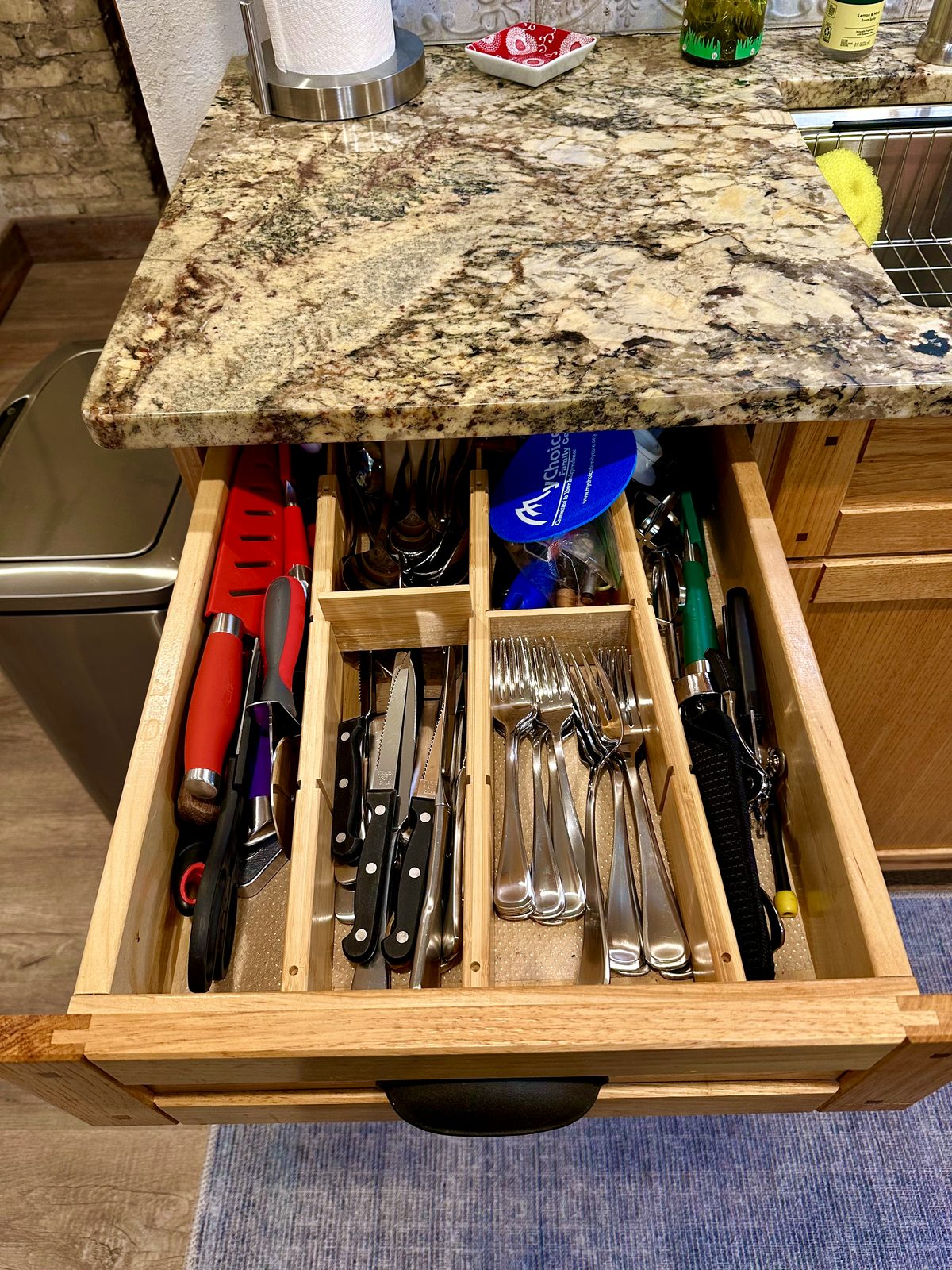 Stocked kitchen drawer with knives, utensils, and flatware