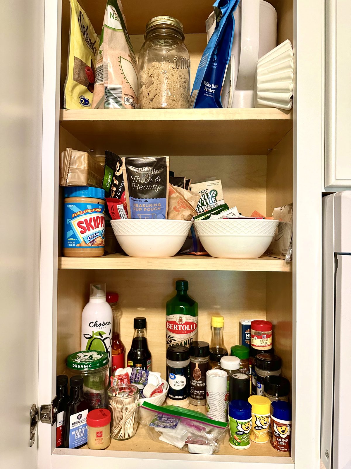 Stocked kitchen pantry with spices, oils, and cooking basics