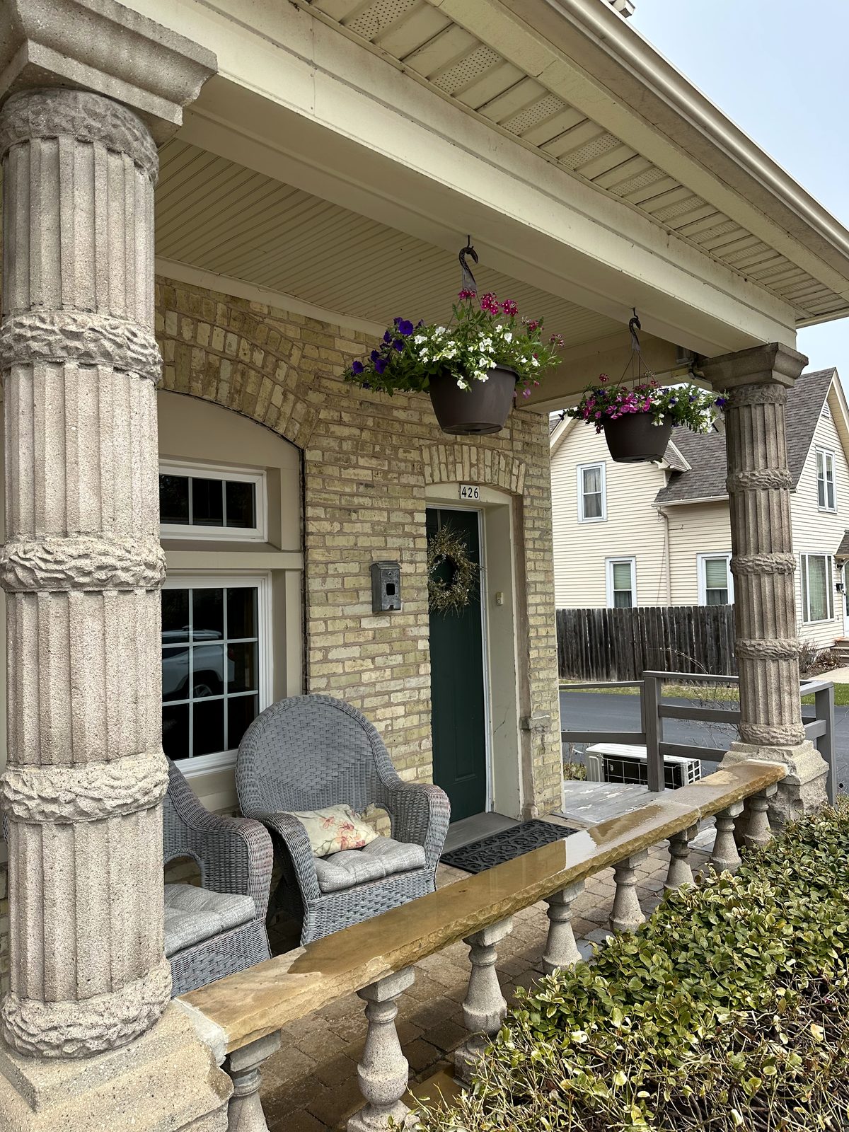 Porch columns, seating, and hanging flowers