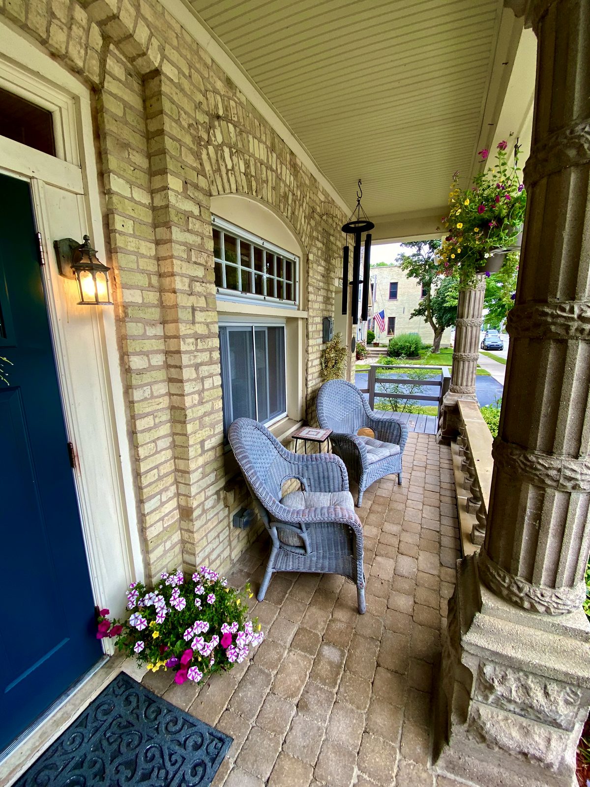 Porch chairs beside a teal entry door