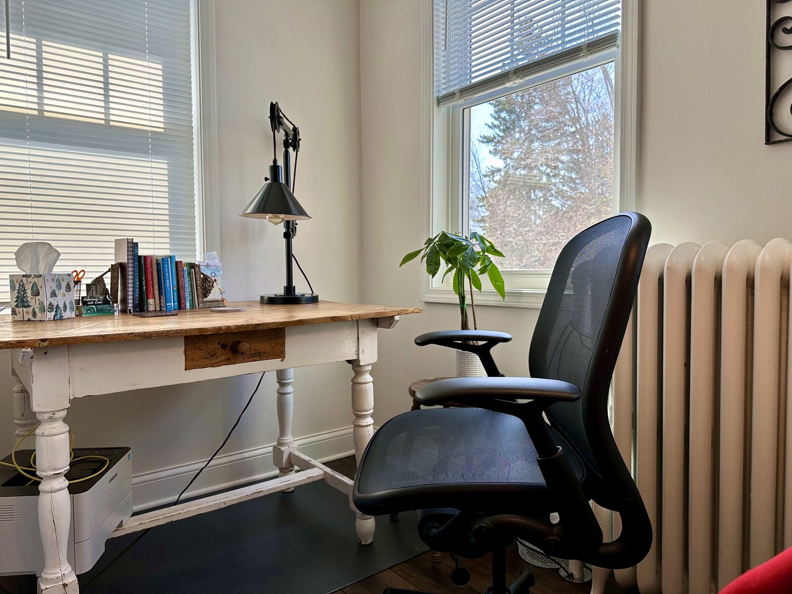 Work desk with lamp, books, and office chair