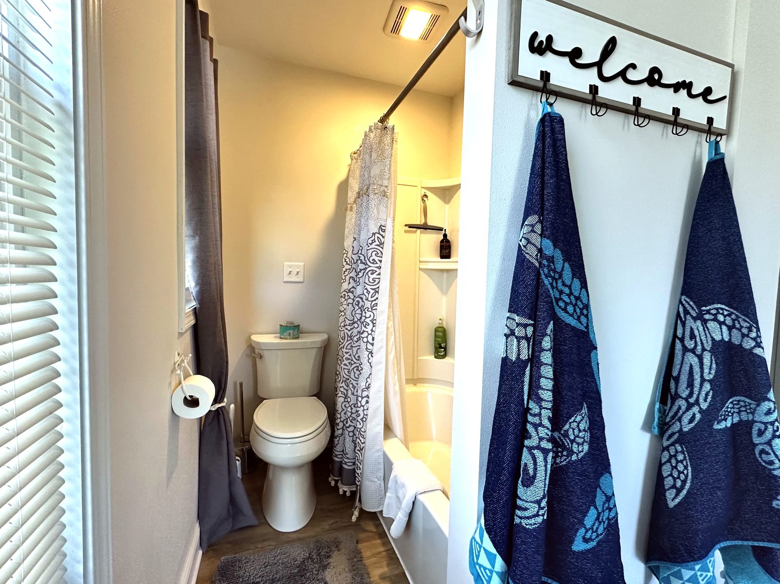 Bathroom with tub and shower beside a welcome hook rack