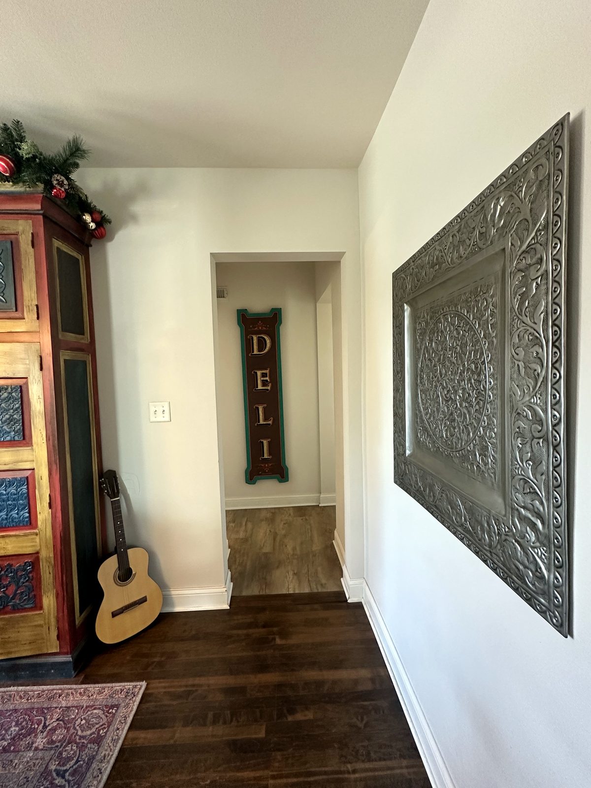Entry hallway with guitar, painted armoire, and wall art