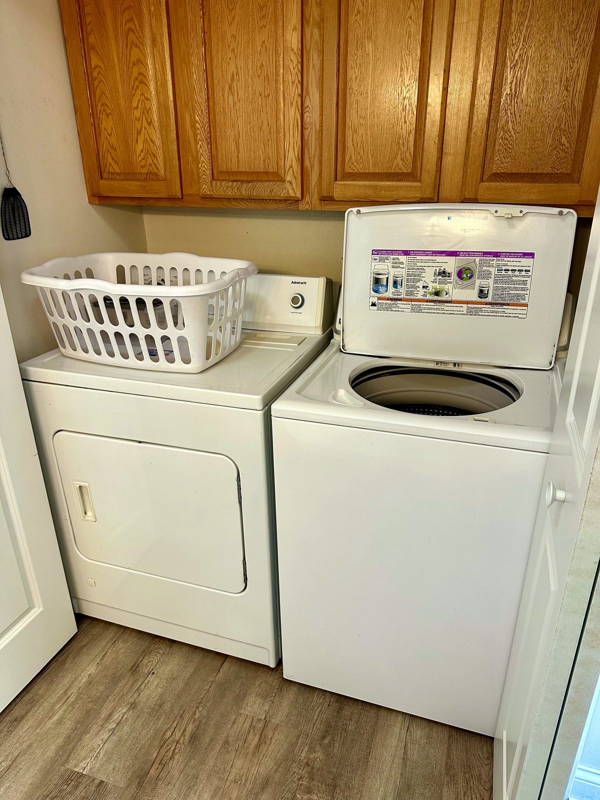 Laundry area with washer, dryer, and wood cabinets